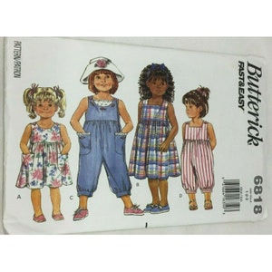 May include: A sewing pattern for girls' clothing, featuring four different styles: a floral sundress, denim overalls, a plaid dress, and striped overalls. The pattern is from Butterick and is labeled "Fast & Easy" with the number 6818.
