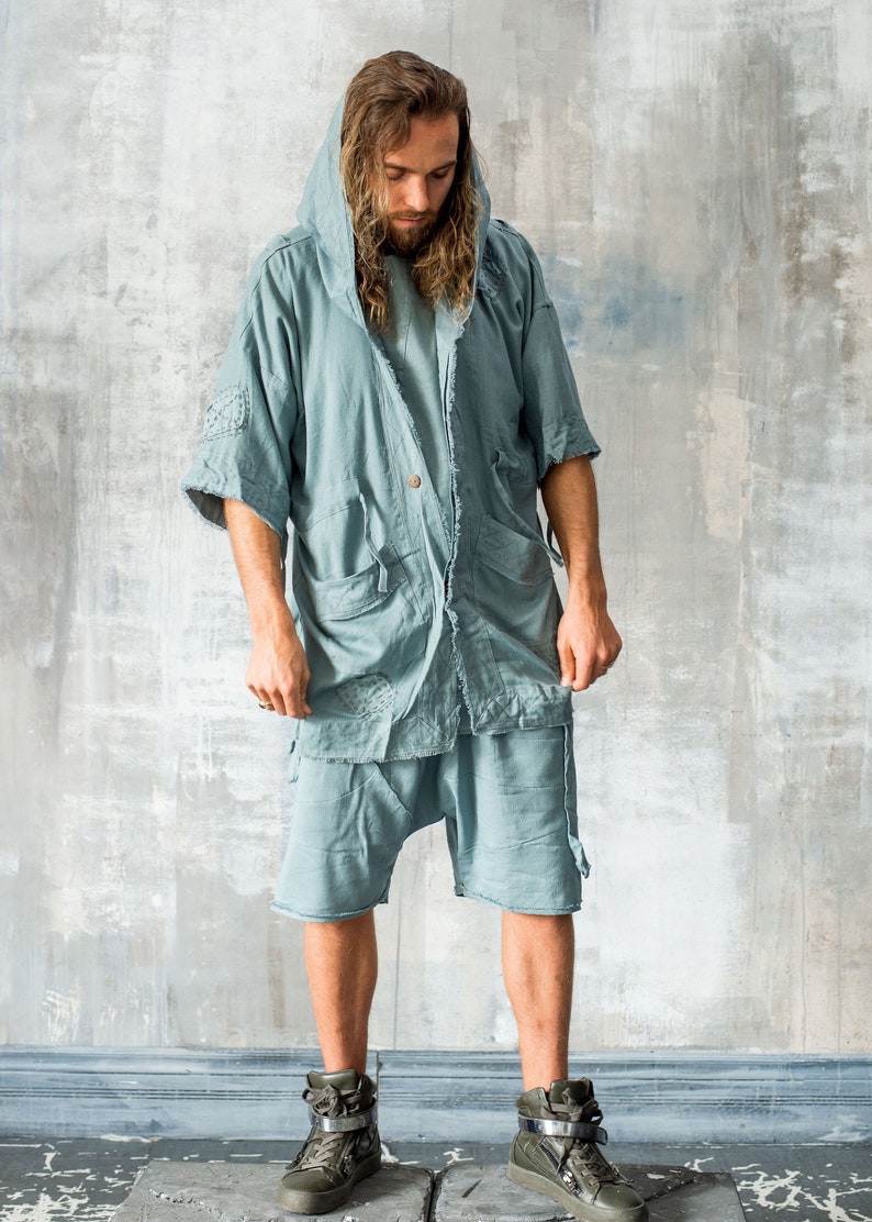 Puede incluir: Conjunto de chaqueta con capucha y pantal&oacute;n corto de color verde azulado claro. La chaqueta tiene mangas cortas, m&uacute;ltiples bolsillos y cierre de bot&oacute;n. El pantal&oacute;n corto es holgado. El conjunto se combina con zapatillas altas verde oliva con hebillas plateadas.