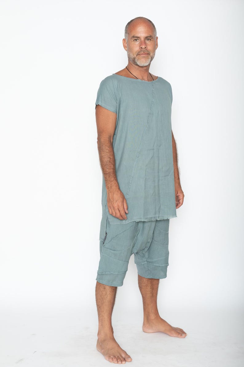 Puede incluir: Conjunto de t&uacute;nica y pantal&oacute;n corto de lino verde azulado claro. La t&uacute;nica tiene cuello barco y mangas cortas. El pantal&oacute;n corto llega a la rodilla con un corte relajado. La tela parece tener un aspecto texturizado y lavado. El conjunto lo lleva una persona.