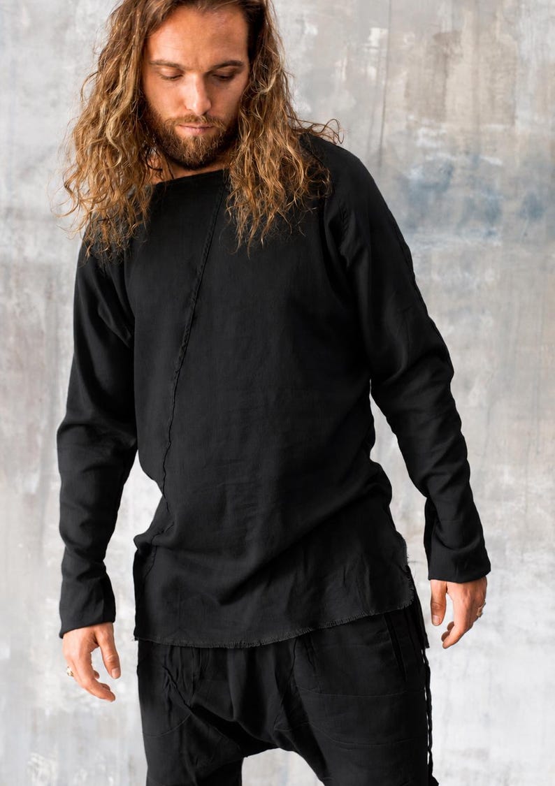 May include: Black long-sleeve shirt and matching pants. The shirt has a unique square neckline and a vertical seam down the front. The pants have a relaxed fit. The outfit is made of a soft, flowing fabric.