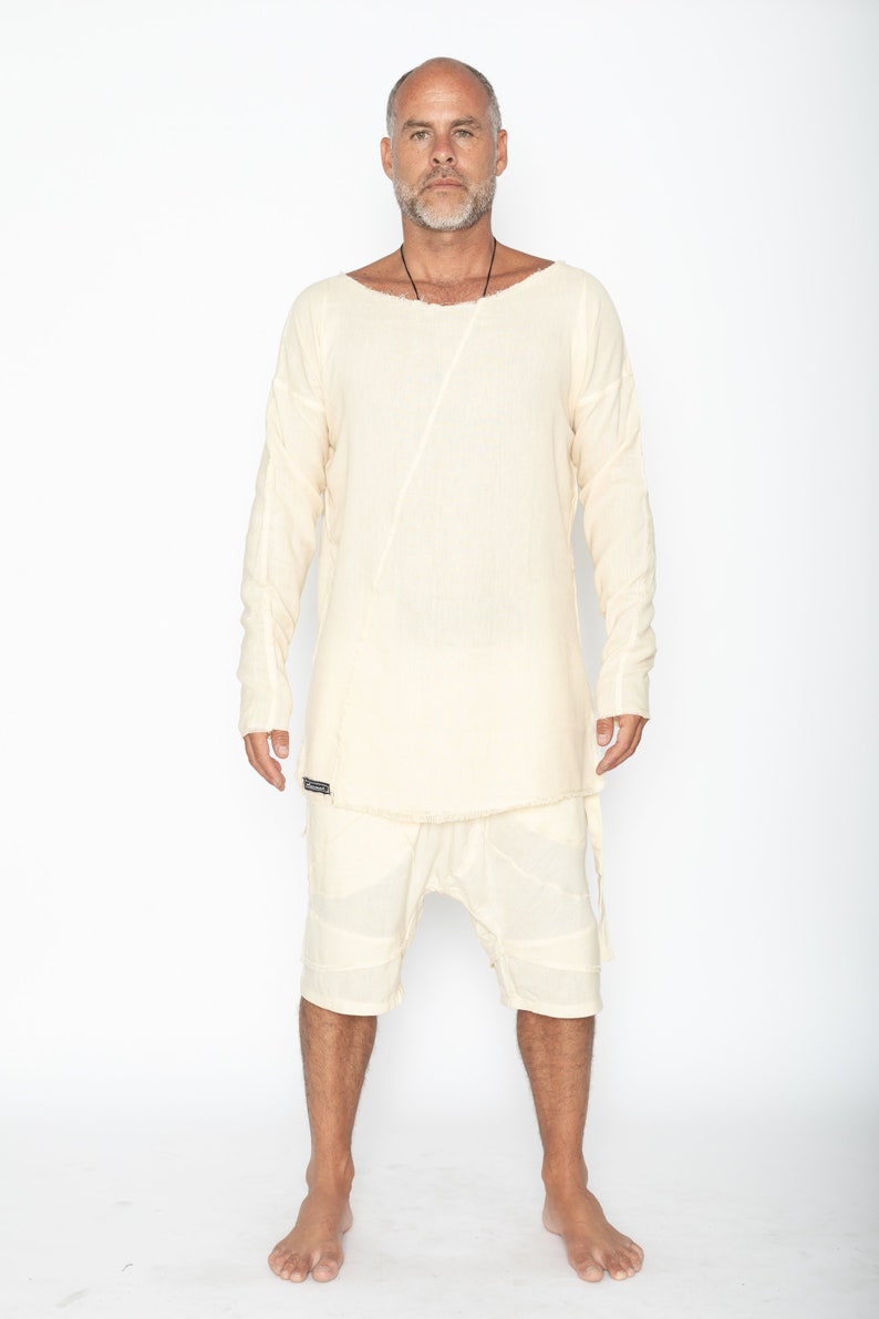 Puede incluir: Conjunto de camisa y pantal&oacute;n corto de lino color crema. La camisa tiene cuello barco y una costura diagonal en la parte delantera. El pantal&oacute;n corto tiene un dise&ntilde;o en capas. El conjunto lo lleva una persona.