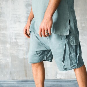 Puede incluir: Conjunto de lino azul claro, compuesto por una t&uacute;nica y pantalones cortos. La parte superior tiene un dobladillo sin rematar y aberturas laterales. Los pantalones cortos tienen un dise&ntilde;o en capas. El conjunto se combina con zapatillas altas verde oliva.