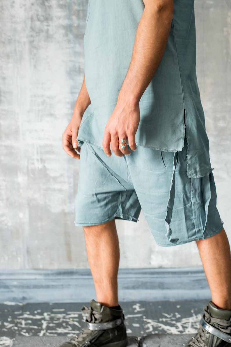 Puede incluir: Conjunto de lino azul claro, compuesto por una t&uacute;nica y pantalones cortos. La parte superior tiene un dobladillo sin rematar y aberturas laterales. Los pantalones cortos tienen un dise&ntilde;o en capas. El conjunto se combina con zapatillas altas verde oliva.