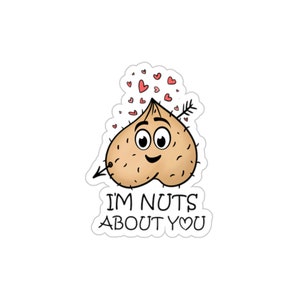 May include: A cartoon illustration of a nut with a face and an arrow through it. The nut is surrounded by hearts and the text "I'm nuts about you".