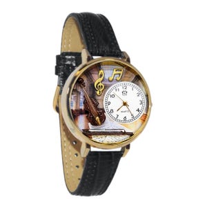 May include: A gold-toned quartz watch with a black leather band. The watch face features a violin, musical notes, and a treble clef. The watch has a white clock face with black numbers and hands.