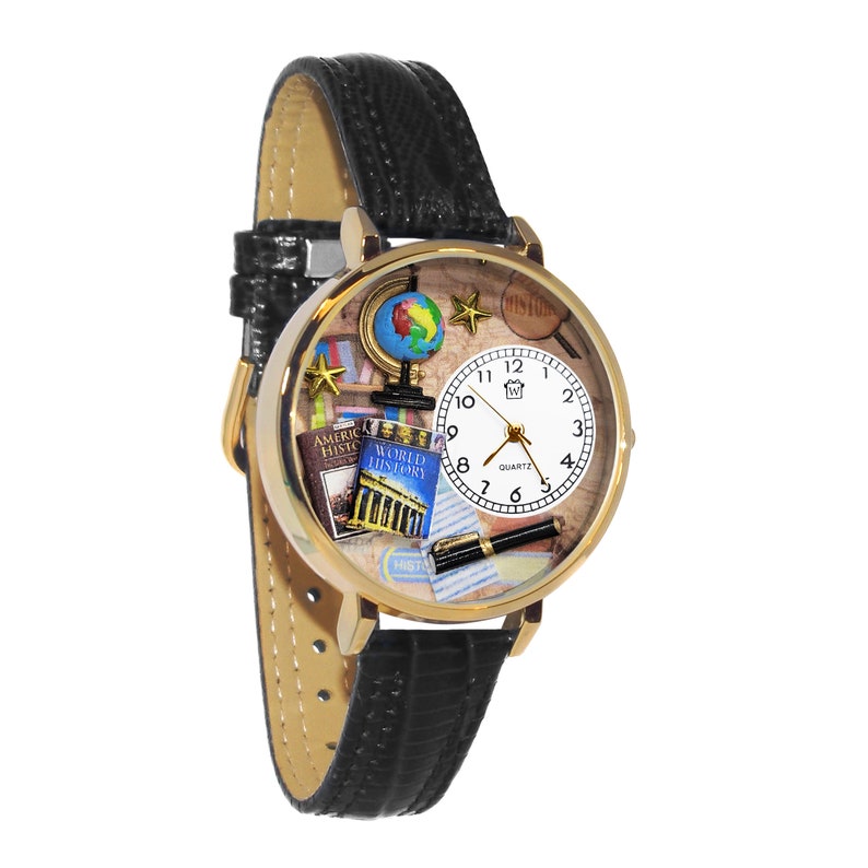 K&ouml;nnte beinhalten: Vergoldete Quarzuhr mit schwarzem Lederarmband. Das Zifferblatt der Uhr zeigt einen Miniaturglobus, B&uuml;cher und einen Stift, mit den W&ouml;rtern "America History" und "World History". Das Zifferblatt ist wei&szlig; mit schwarzen Ziffern.