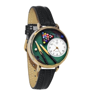 May include: A gold-tone wristwatch with a black leather band. The watch face features a green felt pool table design with billiard balls, cues, and a white clock face. The watch has a quartz movement.