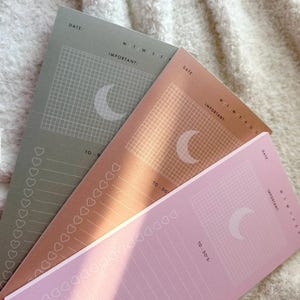 May include: Three rectangular to-do list notepads in sage green, copper, and light pink. Each notepad features a date line, days of the week, an important section with a grid and crescent moon icon, and a to-do list column with heart-shaped checkboxes.