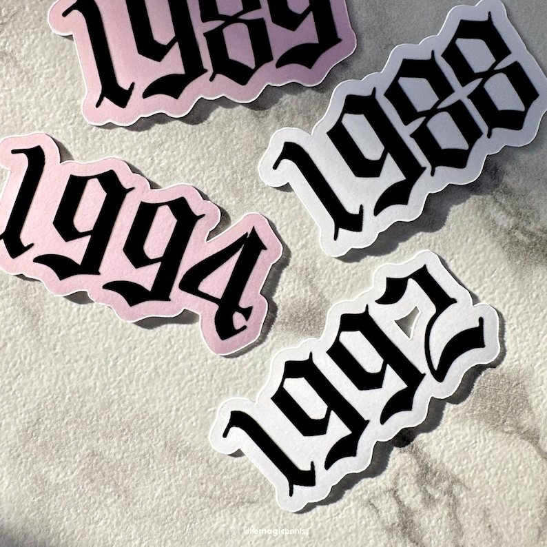 May include: Four stickers with different years in black gothic font on white and pink backgrounds. The years are 1999, 1994, 1998, and 1992.