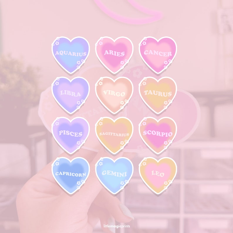 May include: Twelve heart-shaped stickers with the astrological signs of the zodiac. Each sticker is a different pastel color with white outlines and white text. The signs are: Aquarius, Aries, Cancer, Libra, Virgo, Taurus, Pisces, Sagittarius, Scorpio, Capricorn, Gemini, and Leo.