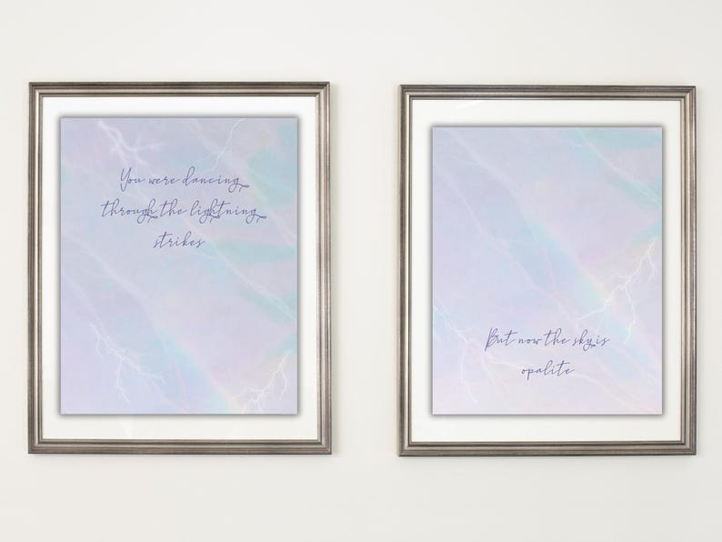 K&ouml;nnte beinhalten: Zwei gerahmte Kunstdrucke mit silberfarbenen Rahmen. Jeder Druck hat einen pastellfarbenen Hintergrund mit Aquarelleffekt und Text. Einer lautet "You were dancing through the lightning strikes". Der andere lautet "But now the sky is opalite."