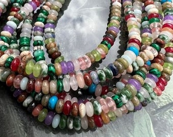 May include: A multi-strand necklace made of various colorful gemstone beads. The beads are round and have a smooth, polished finish. The necklace is a mix of green, blue, pink, red, and white beads.