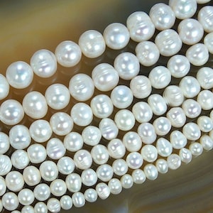 May include: A strand of white freshwater pearls, with a smooth, lustrous finish. The pearls are round and uniform in size, and they are strung on a clear thread. The pearls are arranged in a staggered pattern, creating a beautiful and elegant look.