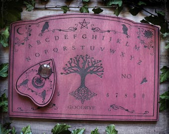 Red wooden ouija board adorned with ravens and tree of life Yggdrasil, spiritualism talking board