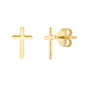 May include: A pair of gold-colored cross stud earrings. The earrings are displayed on a white background. The cross design is simple and elegant, with rounded edges.