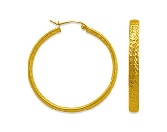 May include: A pair of gold hoop earrings. The earrings have a textured surface and a classic circular design. The earrings are displayed against a white background, highlighting their bright, shiny appearance.