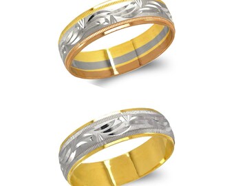 May include: Two gold wedding bands. The top band has a silver floral design on the outer edge, with a rose gold and silver inner band. The bottom band is gold with a silver floral design.