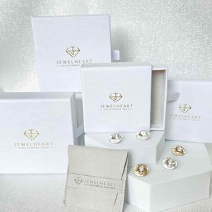 May include: Four white boxes with the logo 'Jewelheart - California 2013' and a small white pouch with the same logo. The boxes are arranged in a pyramid shape with the pouch in front.