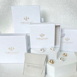 May include: Four white boxes with the logo 'Jewelheart - California 2013' and a small white pouch with the same logo. The boxes are arranged in a pyramid shape with the pouch in front.