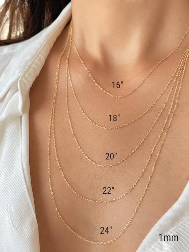 Five 14k solid yellow gold twisted rope chains of different lengths, 16 inches, 18 inches, 20 inches, 22 inches, and 24 inches, are layered on a model's neck. The chains are all the same width, 1mm.