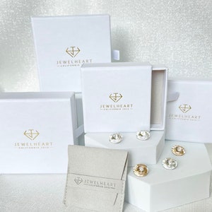 May include: Four white boxes with the logo 'Jewelheart - California 2013' and a small white pouch with the same logo. The boxes are arranged in a pyramid shape with the pouch in front.