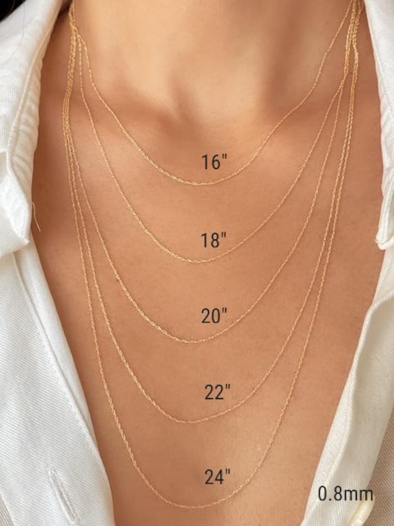 Five 14k yellow solid gold twisted rope chains of different lengths, 16 inches, 18 inches, 20 inches, 22 inches, and 24 inches, are layered on a model's neck. The chains are all the same width, 0.8mm.