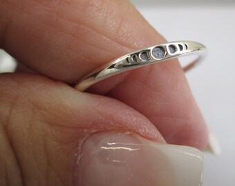 May include: A silver ring with a delicate design of crescent moons and stars.