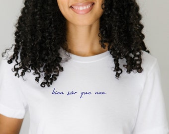 May include: White t-shirt with the text "bien sur que non" in blue cursive writing.