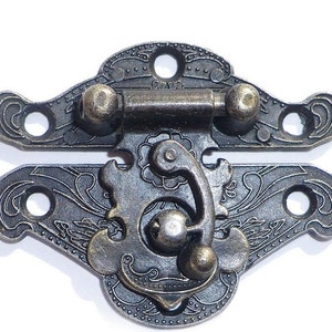 May include: Antique-style brass latch with a decorative floral design. The latch has a hinged mechanism and a spring-loaded catch.