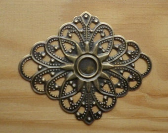 May include: A decorative metal embellishment with a floral design. The embellishment is made of brass and has a dark, antique finish.