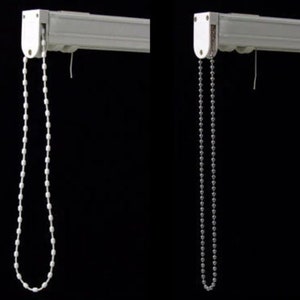 May include: Two white window blind brackets with different types of pull chains. One chain is white plastic and the other is silver metal.