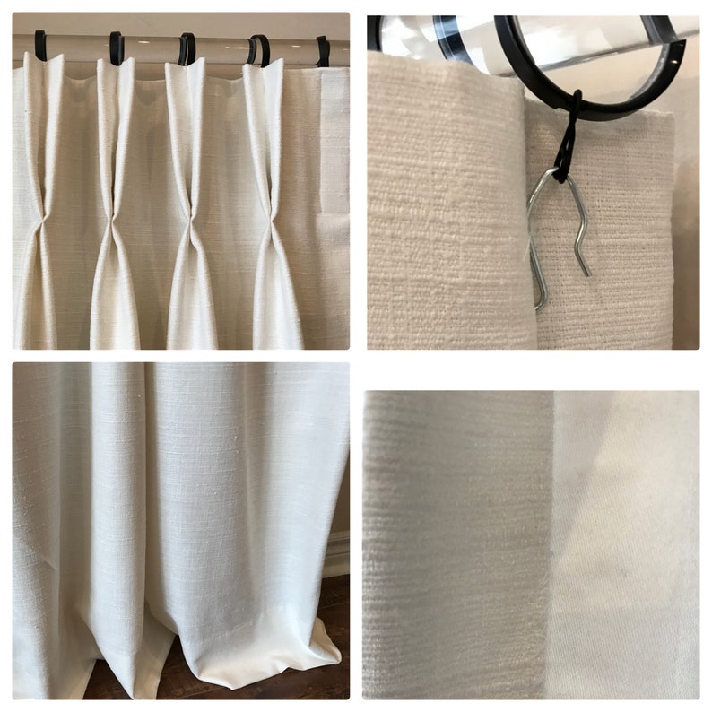 May include: Close-up of white curtains with pleats and a black curtain rod. The curtains are made of a textured fabric and have a subtle sheen.