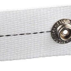 May include: Close-up of a white fabric strap with a metal snap closure. The strap has a black stitched line running along its length. The snap is circular and has a detailed design.