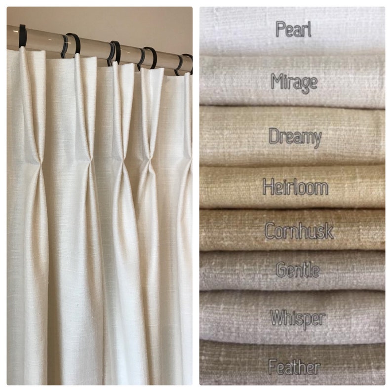 May include: Close-up of white linen curtains with pleats.  The curtains are hanging from a rod with silver rings.  The image also shows a stack of fabric swatches in various shades of white, beige, and brown.  The swatches are labeled with names like "Pearl", "Mirage", "Dreamy", "Heirloom", "Cornhusk", "Gentle", "Whisper", and "Feather".