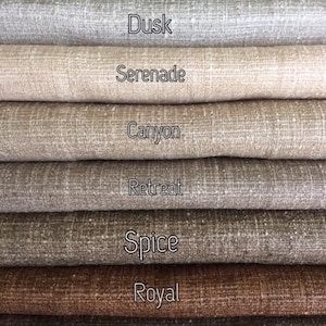 May include: Close-up of eight fabric swatches in various shades of brown and beige. The swatches are labeled with the names "Innocence", "Dusk", "Serenade", "Canyon", "Retreat", "Spice", "Royal", and "Reserve".