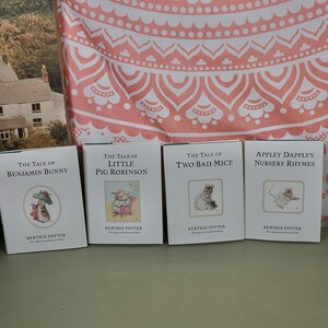 May include: Four small, colourful hardback books with illustrations on the covers. The books are titled "The Tale of Benjamin Bunny", "The Tale of Little Pig Robinson", "The Tale of Two Bad Mice", and "Appley Dapply's Nursery Rhymes". All books are by Beatrix Potter.