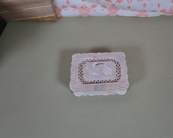 May include: A white, intricately carved, rectangular box with a floral design on the lid.