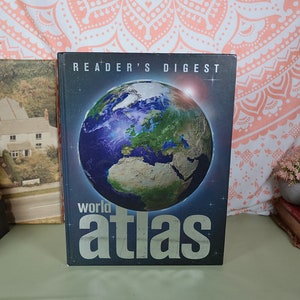 May include: A blue and green world atlas book with the title "Reader's Digest world atlas" on the cover.