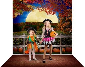 May include: A photography backdrop featuring a nighttime autumn scene with a large full moon, orange and red fall foliage, a wooden fence, and a pumpkin patch. The scene includes a dirt ground foreground and a dark blue sky with trees.