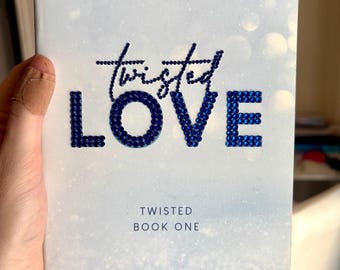 May include: A book cover with the title "Twisted Love" in a sparkling blue font. The author's name, Ana Huang, is printed at the bottom. The cover has a light blue background with the text "He has a heart of ice...but for her, he'd burn the world."