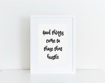 May include: A framed print with the quote "Good things come to those that hustle" in black script. The white frame surrounds the text on a white background, set against a white surface and wall.