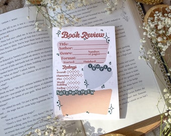 May include: A pink and white printable book review tracker with a whimsical design. The tracker includes sections for title, author, genre, format, started, finished, number of pages, ratings, notes, and quotes. The tracker is decorated with stars, hearts, and a floral pattern.