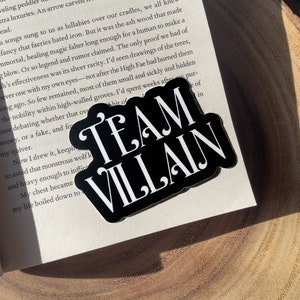May include: Black and white sticker with the text "TEAM VILLAIN" in bold white letters on a black background.