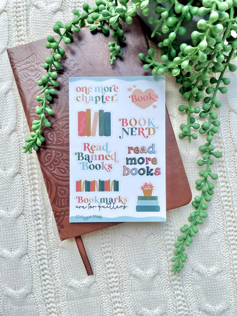 May include: A sheet of colorful stickers with book-themed designs. The stickers feature phrases like "one more chapter", "Book Nerd", "Read Banned Books", and "Read More Books".
