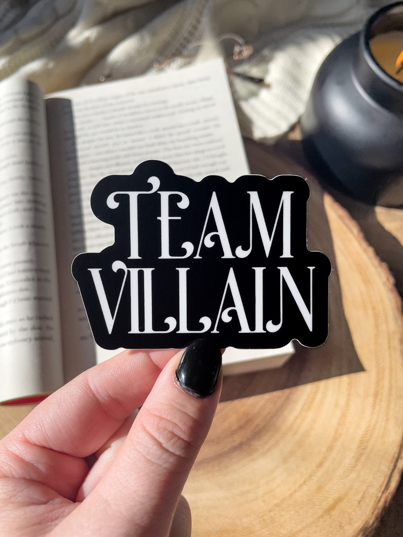 May include: Black and white sticker with the text "TEAM VILLAIN" in a decorative font.