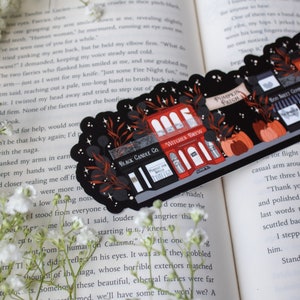 May include: Two illustrated stickers featuring a black and red storefront with the text "Black Candle Co." and "Witches Brew" on a black background with stars and leaves. The text "Pumpkin Patch" is on a banner above the storefront.
