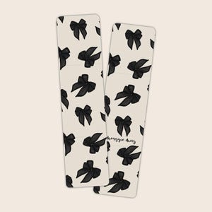 May include: Two black and white bookmark designs with a repeating pattern of black bows. The text "heggie mooy" is written on the bottom right bookmark.
