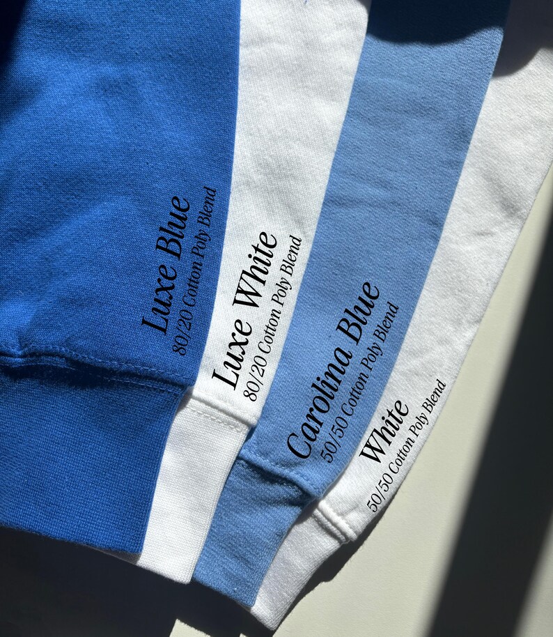 May include: Four fabric swatches in royal blue, white, light blue, and white. Text printed on the fabric reads: Luxe Blue 80/20 Cotton Poly Blend, Luxe White 80/20 Cotton Poly Blend, Carolina Blue 50/50 Cotton Poly Blend, and White 50/50 Cotton Poly Blend.