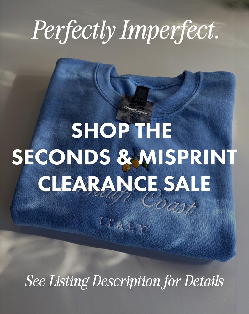 May include: A light blue crewneck sweatshirt featuring an embroidered design of yellow lemons with green leaves above the text Amalfi Coast and ITALY. The garment includes a tag labeled simple&stellar and text overlays reading Perfectly Imperfect. SHOP THE SECONDS & MISPRINT CLEARANCE SALE See Listing Description for Details.