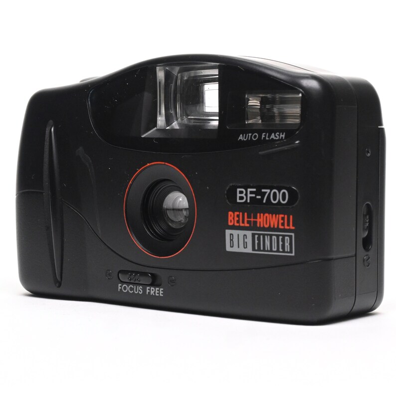 Pode incluir: Uma c&acirc;mera preta Bell + Howell BF-700 com um r&oacute;tulo vermelho "BIG FINDER". A c&acirc;mera tem um flash embutido e uma lente de foco autom&aacute;tico.